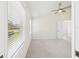 Bright carpeted bedroom with a ceiling fan and two windows with views of the neighborhood at 10169 Holly Berry Dr, Weeki Wachee, FL 34613