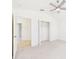 Bright bedroom featuring carpet, a ceiling fan, closet, and views to the hallway at 10169 Holly Berry Dr, Weeki Wachee, FL 34613