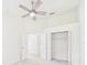 Spacious carpeted bedroom with a closet, doorway and a ceiling fan, illuminated by natural light at 10169 Holly Berry Dr, Weeki Wachee, FL 34613