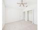 A bright bedroom featuring carpet, ceiling fan, closet, and a window at 10169 Holly Berry Dr, Weeki Wachee, FL 34613