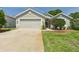 Charming single story home with a two car garage, manicured lawn, and a cozy front porch at 10169 Holly Berry Dr, Weeki Wachee, FL 34613