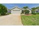 Charming single story home with a two car garage, manicured lawn, and a cozy front porch at 10169 Holly Berry Dr, Weeki Wachee, FL 34613