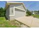 Attached garage on a home featuring a concrete driveway and manicured landscaping at 10169 Holly Berry Dr, Weeki Wachee, FL 34613