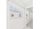 Bright hallway, showing a view of a neighborhood street through a window, leads to a bedroom at 10169 Holly Berry Dr, Weeki Wachee, FL 34613