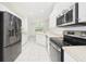 Bright kitchen featuring stainless steel appliances, white cabinetry, and tiled flooring at 10169 Holly Berry Dr, Weeki Wachee, FL 34613