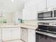 Bright kitchen featuring stainless steel appliances, and white cabinetry at 10169 Holly Berry Dr, Weeki Wachee, FL 34613