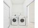 Functional laundry room with modern washer and dryer units and a wire shelf at 10169 Holly Berry Dr, Weeki Wachee, FL 34613