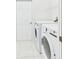 Bright laundry room featuring modern appliances and a convenient storage shelf at 10169 Holly Berry Dr, Weeki Wachee, FL 34613