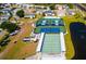 Aerial view features community tennis and shuffleboard courts, along with RV parking and a serene pond at 341 Outrigger Pl, North Port, FL 34287