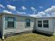 Side view of a home with charming blue shutters with neat landscaping and well-maintained lawn at 341 Outrigger Pl, North Port, FL 34287