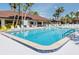 Large swimming pool with a tiled edge and blue water, surrounded by lounge chairs and palm trees at 341 Outrigger Pl, North Port, FL 34287