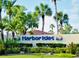 A lush sign for Harbor Isles with colorful graphics and manicured landscaping on a sunny day at 341 Outrigger Pl, North Port, FL 34287