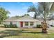 Charming single-story home featuring a bright red front door and lush lawn at 1103 W Dixie St, Plant City, FL 33563