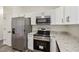 Modern kitchen featuring stainless steel appliances, granite countertops, and white cabinetry at 1103 W Dixie St, Plant City, FL 33563