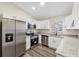 Modern kitchen with stainless steel appliances, granite countertops, and white cabinets at 1103 W Dixie St, Plant City, FL 33563