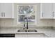 Kitchen sink with a view to the exterior, featuring granite countertops and white cabinetry at 1103 W Dixie St, Plant City, FL 33563