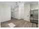 Open living room area featuring wood flooring, white doors, and a stainless steel refrigerator at 1103 W Dixie St, Plant City, FL 33563