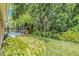 Spacious backyard featuring a screened-in pool, mature trees, and lush landscaping at 11924 Northumberland Dr, Tampa, FL 33626