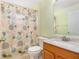 Bathroom featuring a floral shower curtain, vanity, and tile flooring at 11924 Northumberland Dr, Tampa, FL 33626