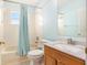 Bright bathroom featuring a tub and shower with blue accents and a vanity at 11924 Northumberland Dr, Tampa, FL 33626
