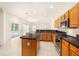 Well-lit kitchen with oak cabinets, tiled backsplash, granite countertops, and stainless steel appliances at 11924 Northumberland Dr, Tampa, FL 33626