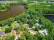 Wide aerial view of a neighborhood with mature trees surrounding homes and access to a lake at 6317 Discovery Ln, Land O Lakes, FL 34638