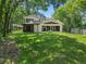 Expansive backyard featuring a modern two-story home with large windows and a screened porch at 6317 Discovery Ln, Land O Lakes, FL 34638