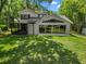 Expansive backyard featuring a modern two-story home with large windows and a screened porch at 6317 Discovery Ln, Land O Lakes, FL 34638