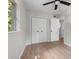 Cozy bedroom with closet, window and ceiling fan with light colored walls and wood flooring at 6317 Discovery Ln, Land O Lakes, FL 34638