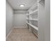 Walk-in closet with tiled flooring, overhead lighting and white shelving and hanging rods for maximum storage at 6317 Discovery Ln, Land O Lakes, FL 34638