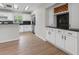 Bright kitchen features white cabinetry, stainless steel appliances, black countertops and wood-look floors at 6317 Discovery Ln, Land O Lakes, FL 34638
