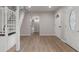 Entry way into a living room showing a staircase and a glass paneled door with light wood flooring at 6317 Discovery Ln, Land O Lakes, FL 34638
