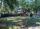 Spacious backyard featuring a lush lawn, mature trees, and a secure fence, perfect for outdoor activities and relaxation at 1808 Heather Ave, Tampa, FL 33612