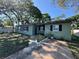 Well-kept single-story home showcasing an inviting entrance, concrete driveway, a tidy lawn, and lush landscaping at 1808 Heather Ave, Tampa, FL 33612