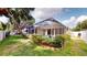 Lush backyard with a screened pool area, colorful garden, and a well-manicured lawn at 4506 Gentrice Dr, Valrico, FL 33596