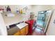 Functional laundry room boasts red washer/dryer, storage shelves, and a sink for added convenience at 4506 Gentrice Dr, Valrico, FL 33596