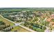 Aerial view of community with lush landscaping, multiple ponds, and beautiful single Gathering homes with red tile roofs at 6621 La Mesa Rd, Land O Lakes, FL 34637