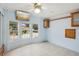 Bedroom featuring bright blue walls, mounted TV and three sunny windows at 6621 La Mesa Rd, Land O Lakes, FL 34637