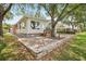 Charming home with a red roof, large windows and a brick patio is surrounded by mature trees and landscaping at 6621 La Mesa Rd, Land O Lakes, FL 34637