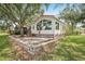 Charming home with a red roof, large windows and a brick patio is surrounded by mature trees and landscaping at 6621 La Mesa Rd, Land O Lakes, FL 34637
