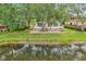 Charming home with a red roof, large windows and a brick patio overlooks a pond and lush landscaping at 6621 La Mesa Rd, Land O Lakes, FL 34637