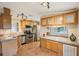 Bright kitchen with stainless steel appliances, wooden cabinets, and speckled countertops at 6621 La Mesa Rd, Land O Lakes, FL 34637