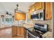 Modern kitchen with wood cabinets, stainless appliances, and granite countertops at 6621 La Mesa Rd, Land O Lakes, FL 34637