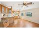 Open kitchen and breakfast nook featuring hardwood floors, wooden cabinets, and large windows at 6621 La Mesa Rd, Land O Lakes, FL 34637