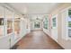 Large sunroom with panel wood floors, doors to the outside and access to other interior rooms at 6621 La Mesa Rd, Land O Lakes, FL 34637