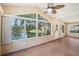 Bright sunroom with paneled wood floors, ceiling fan, and large picture windows overlooking the water at 6621 La Mesa Rd, Land O Lakes, FL 34637