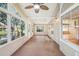 Spacious sunroom with wood floors, multiple doors to outside, and paneled walls at 6621 La Mesa Rd, Land O Lakes, FL 34637