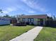 Charming single-story home features a well-maintained front lawn, complemented by neatly trimmed hedges and inviting walkway at 836 41St N Ave, St Petersburg, FL 33703