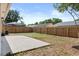 Large backyard with a wood fence, concrete patio, and plenty of space for outdoor activities at 1103 Hardwood Dr, Valrico, FL 33596