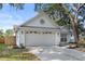 Home exterior featuring a two-car garage, neutral paint and landscaping, and a driveway at 1103 Hardwood Dr, Valrico, FL 33596